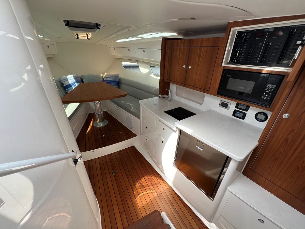 a kitchen with a table and microwave aboard 2023 INTREPID 41 VALOR Yacht for Sale