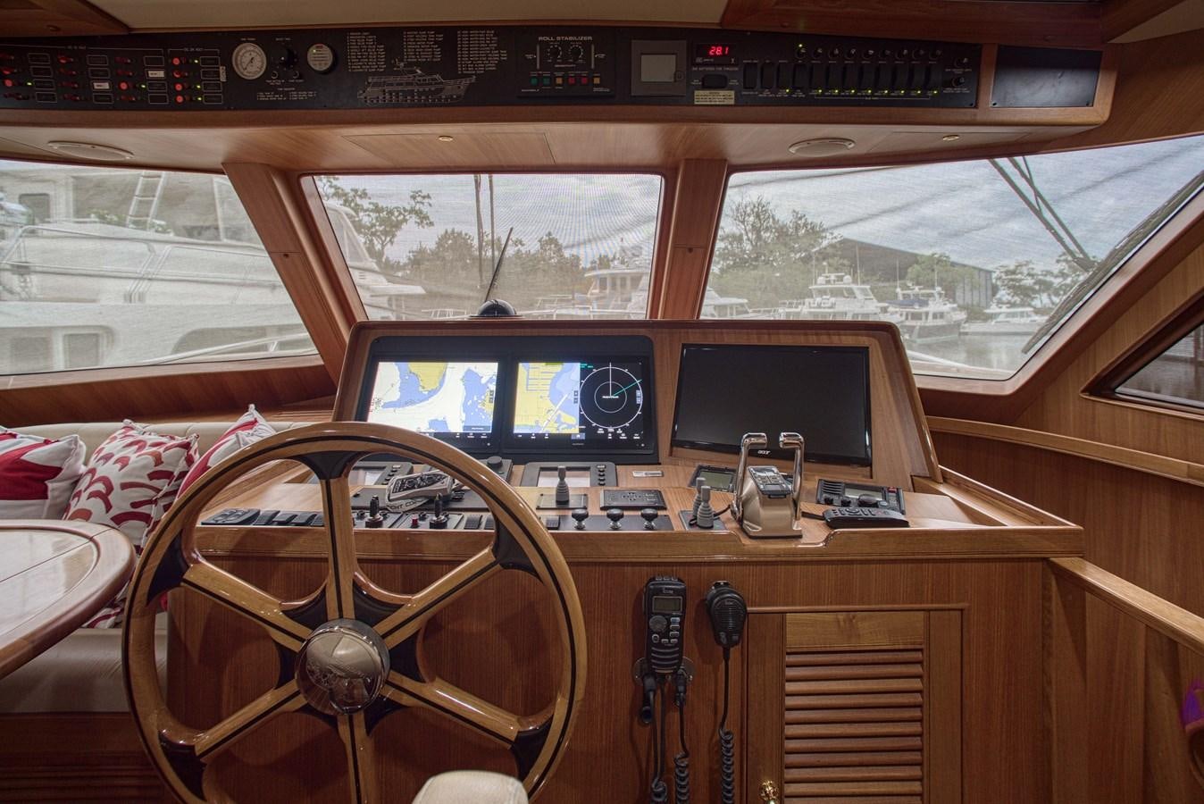 a room with a television and a table with chairs aboard RODE RUNNER II Yacht for Sale