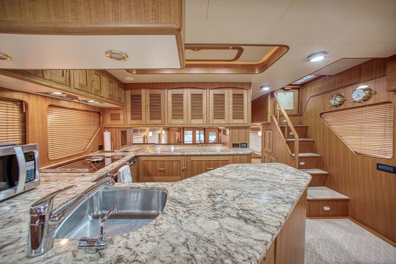 a kitchen with wooden cabinets aboard RODE RUNNER II Yacht for Sale