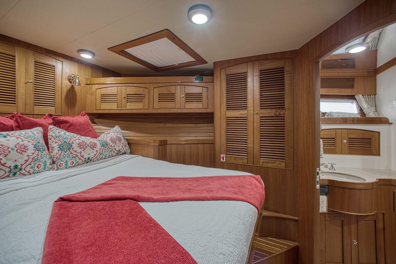 a bedroom with a bed and a desk aboard RODE RUNNER II Yacht for Sale