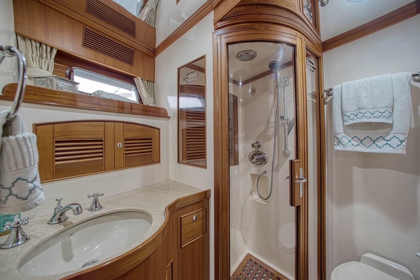 a bathroom with a shower sink and a mirror aboard RODE RUNNER II Yacht for Sale