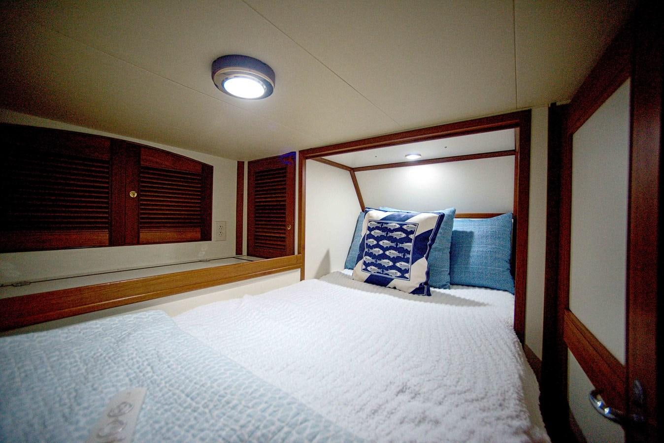 a bed with white sheets aboard RODE RUNNER II Yacht for Sale