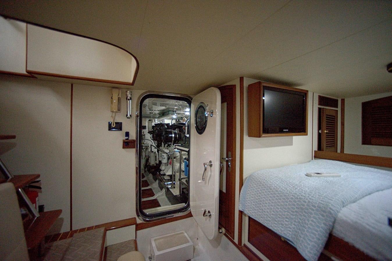 a bedroom with a bed and a tv on the wall aboard RODE RUNNER II Yacht for Sale