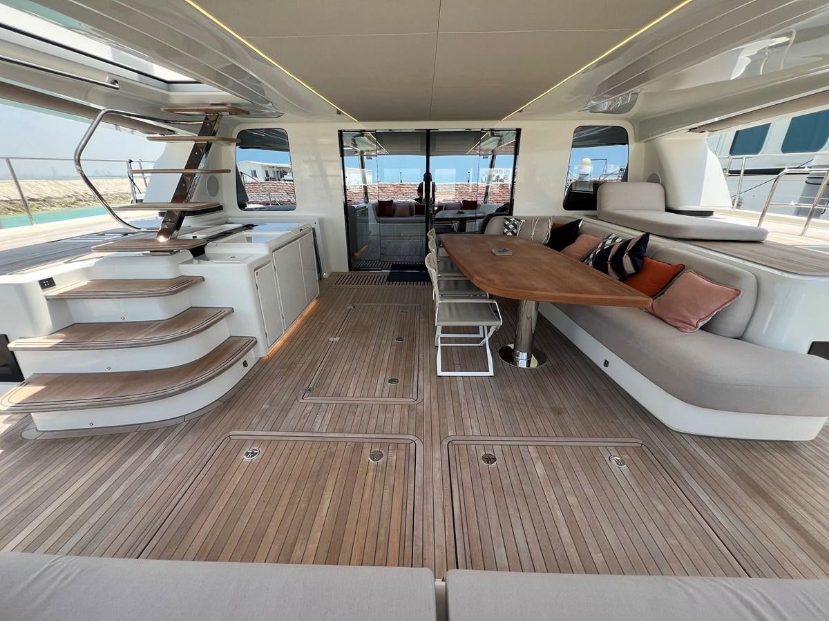 a room with a couch and a table aboard 2023 LAGOON 67 Yacht for Sale