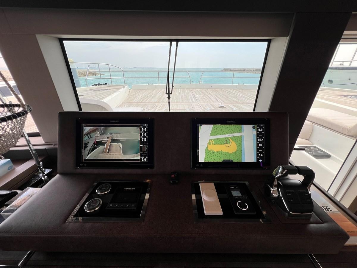a tv and a couple of monitors on a table aboard 2023 LAGOON 67 Yacht for Sale