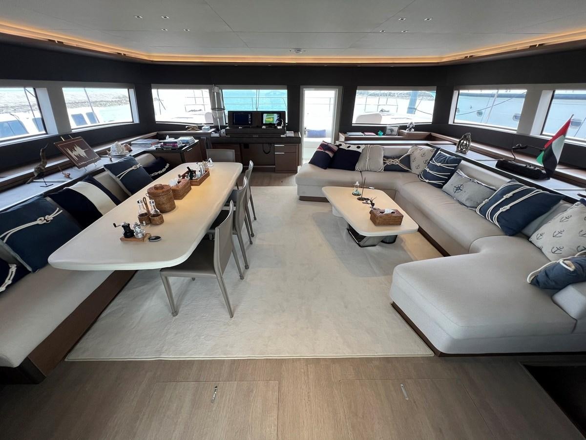 a room with a couch and a table with chairs aboard 2023 LAGOON 67 Yacht for Sale