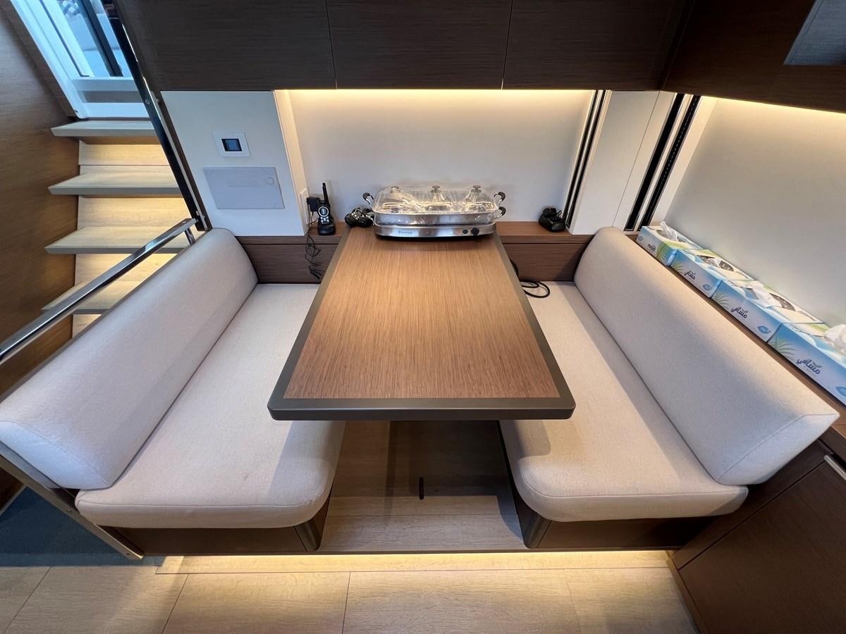 a room with a couch and a table aboard 2023 LAGOON 67 Yacht for Sale