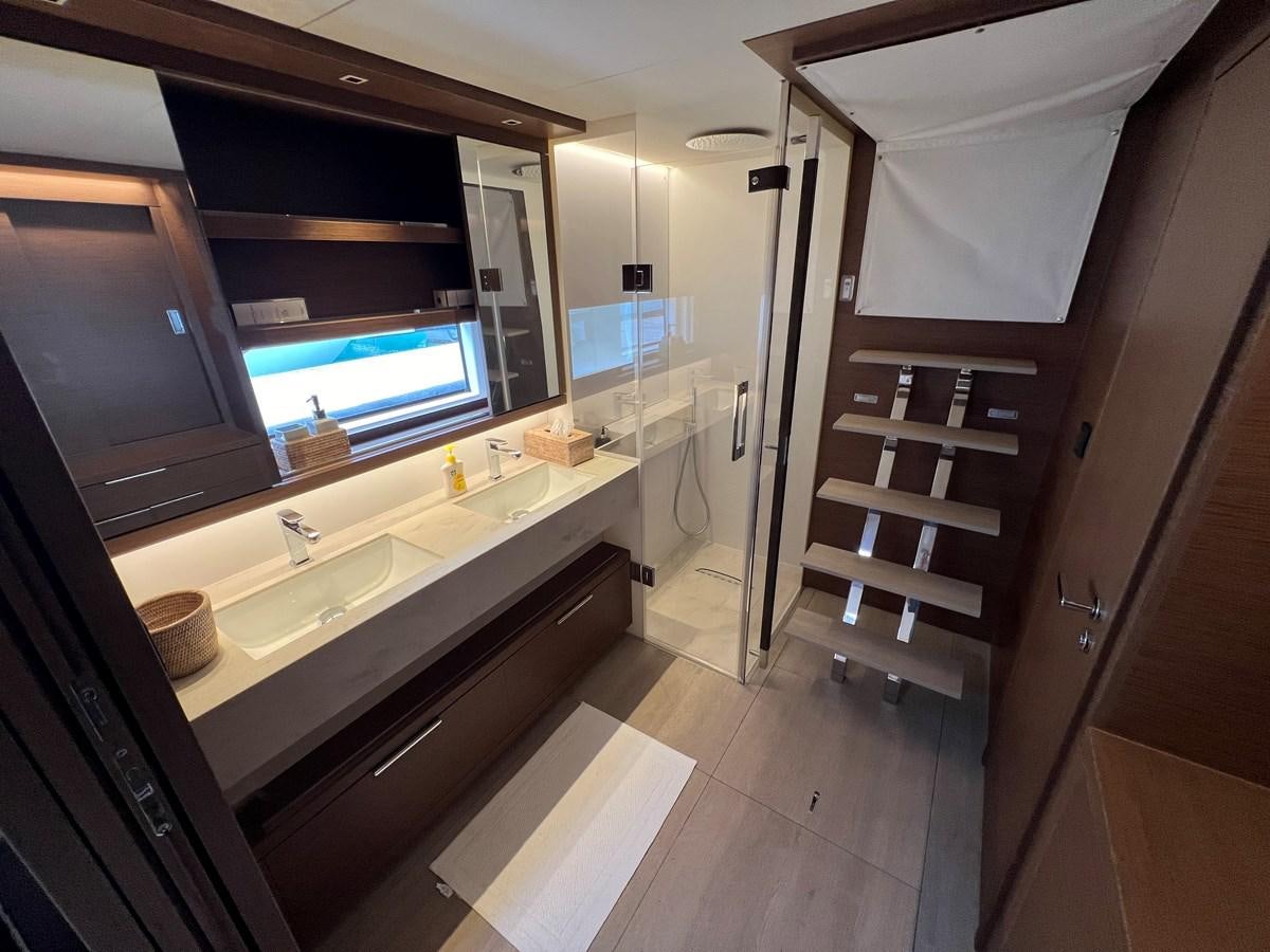 a bathroom with a sink and a mirror aboard 2023 LAGOON 67 Yacht for Sale