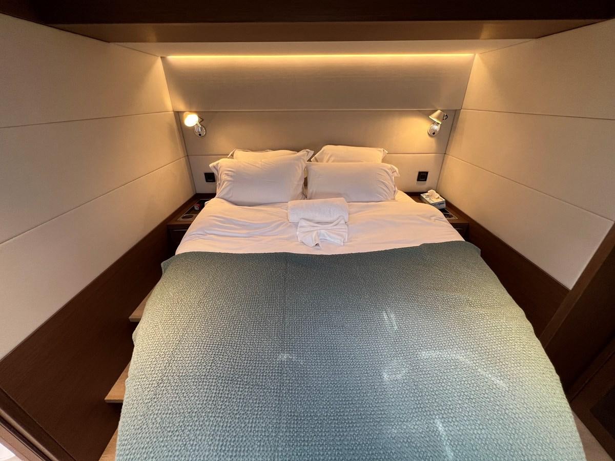 a bed with white sheets aboard 2023 LAGOON 67 Yacht for Sale