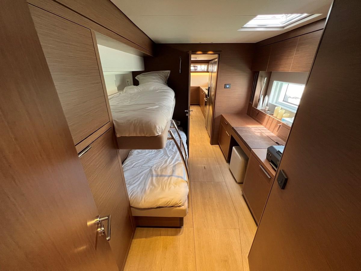 a room with a bed and a desk aboard 2023 LAGOON 67 Yacht for Sale