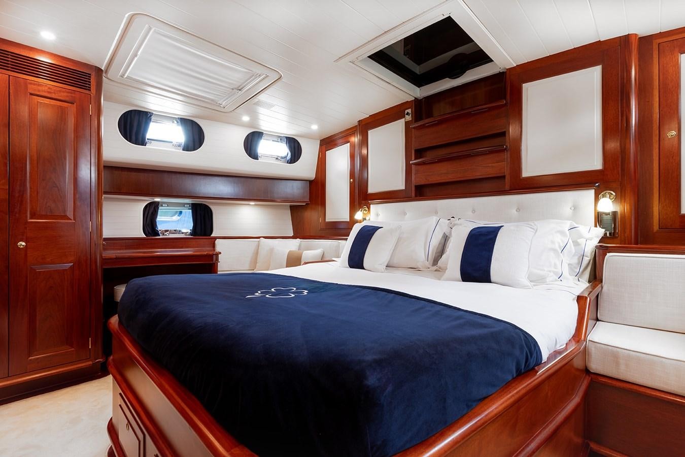 a room with a bed and a wood cabinet aboard IRELANDA Yacht for Sale