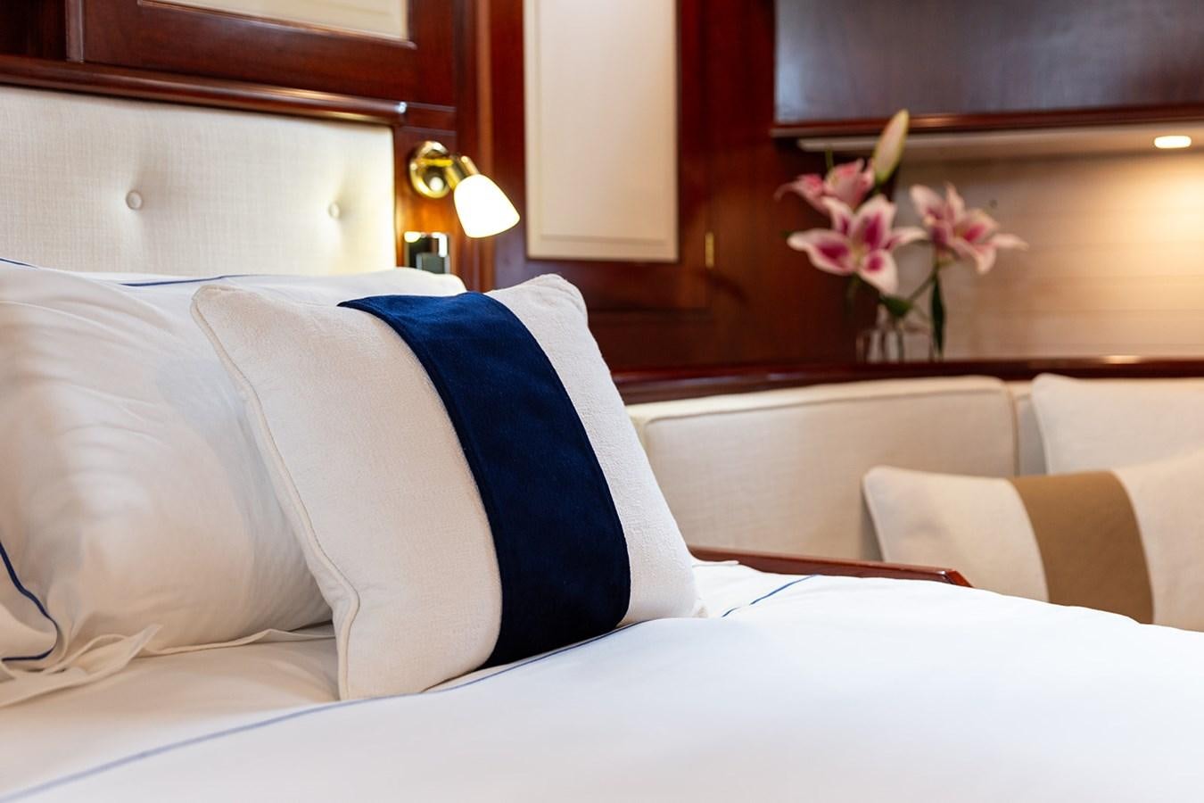 a bed with white sheets and pillows aboard IRELANDA Yacht for Sale