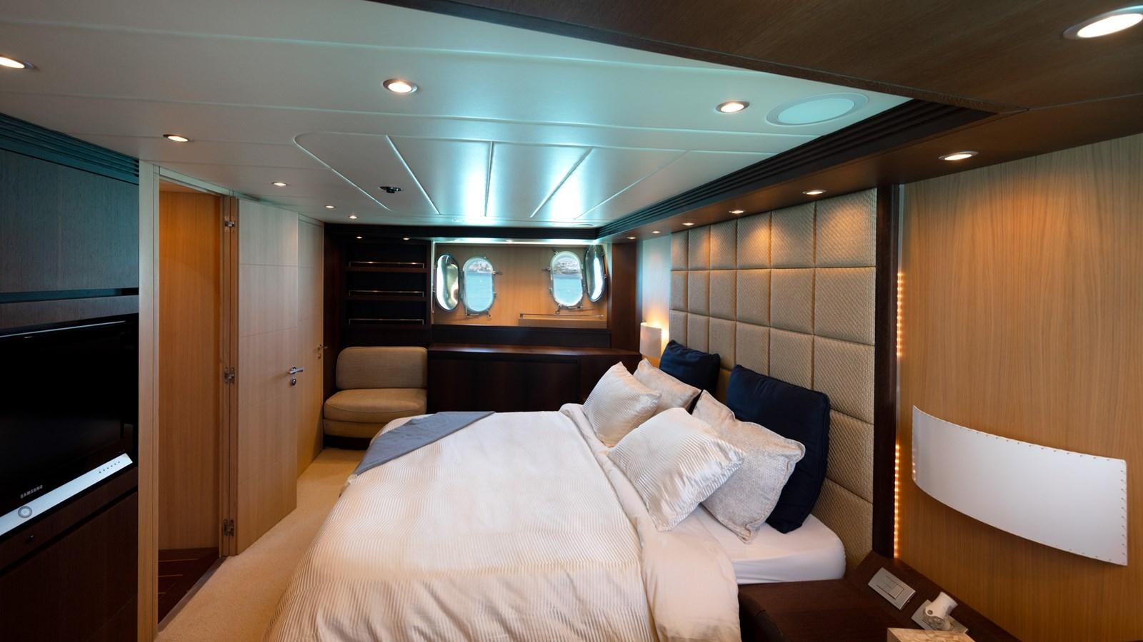 a room with a bed and a chair aboard DOMINIC  2008 MAIORA 27M @ PUERTO AVENTURAS Yacht for Sale