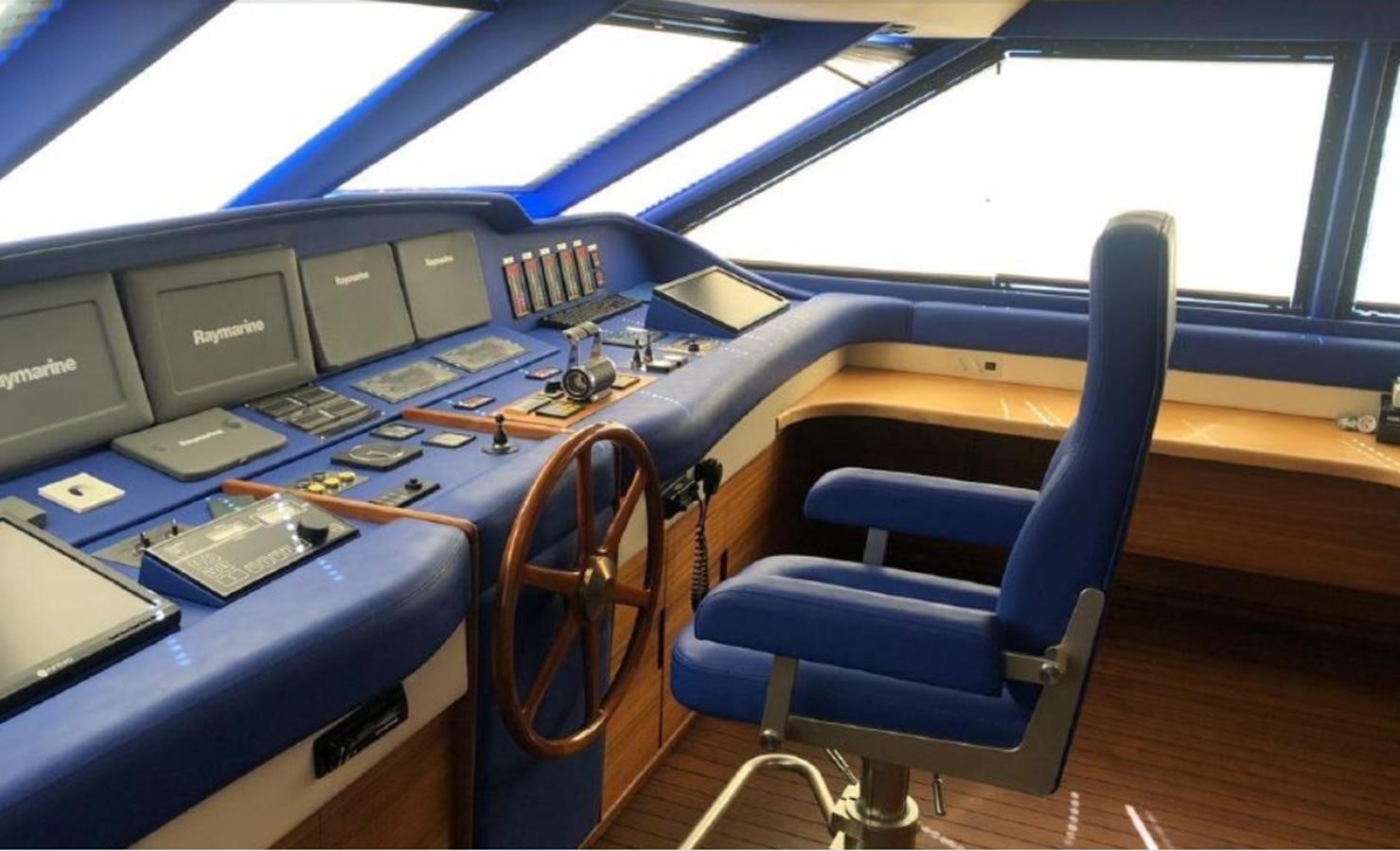 a blue chair in a room with many computers on the floor aboard ORYX Yacht for Sale