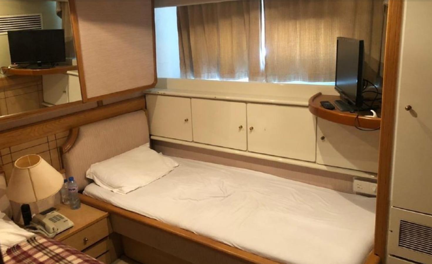 a bed with a white sheet and a television on it aboard ORYX Yacht for Sale