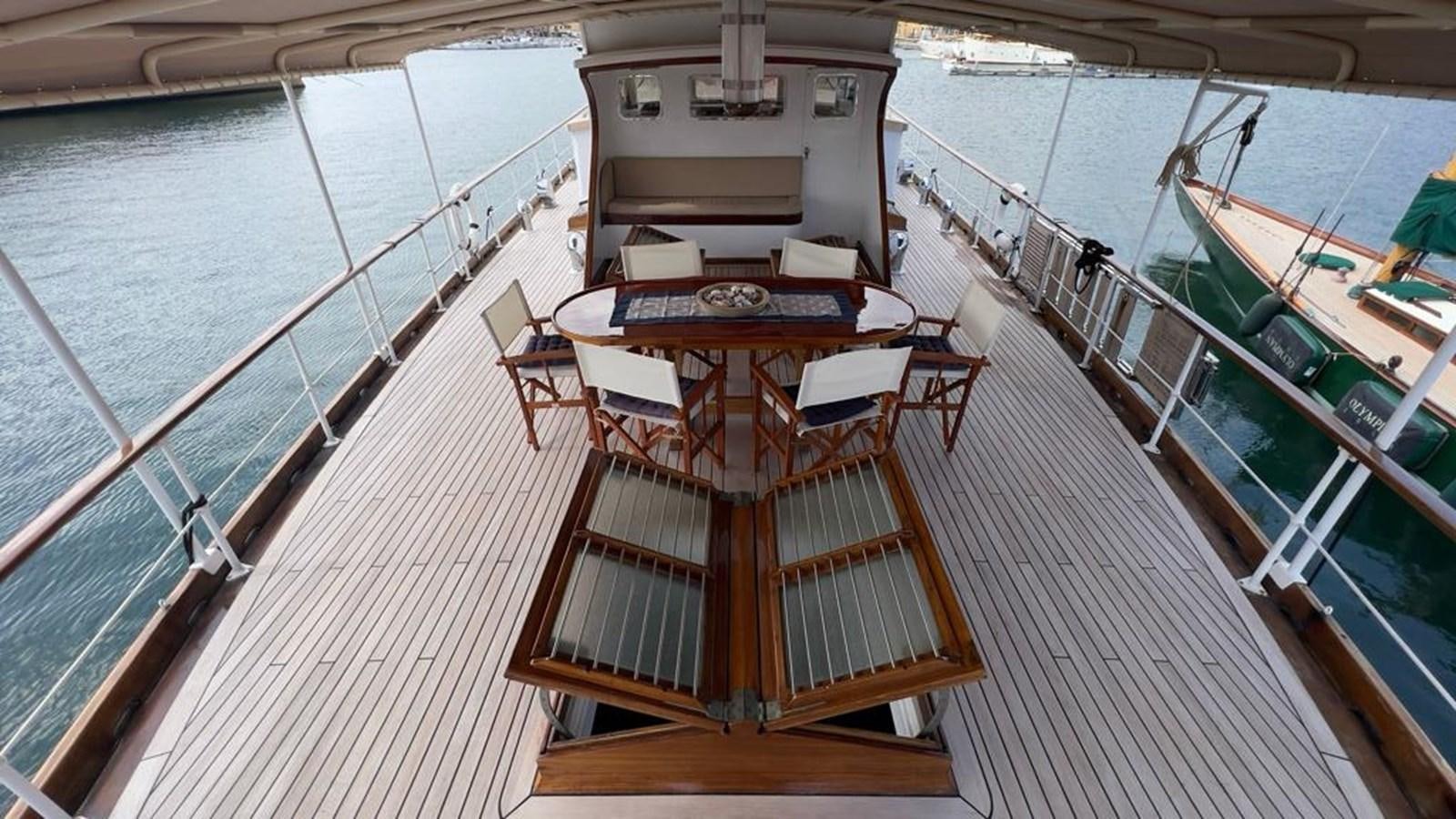 a deck with a table and chairs on it aboard PHILMARBE - ORTIGOZA COFADIC Yacht for Sale