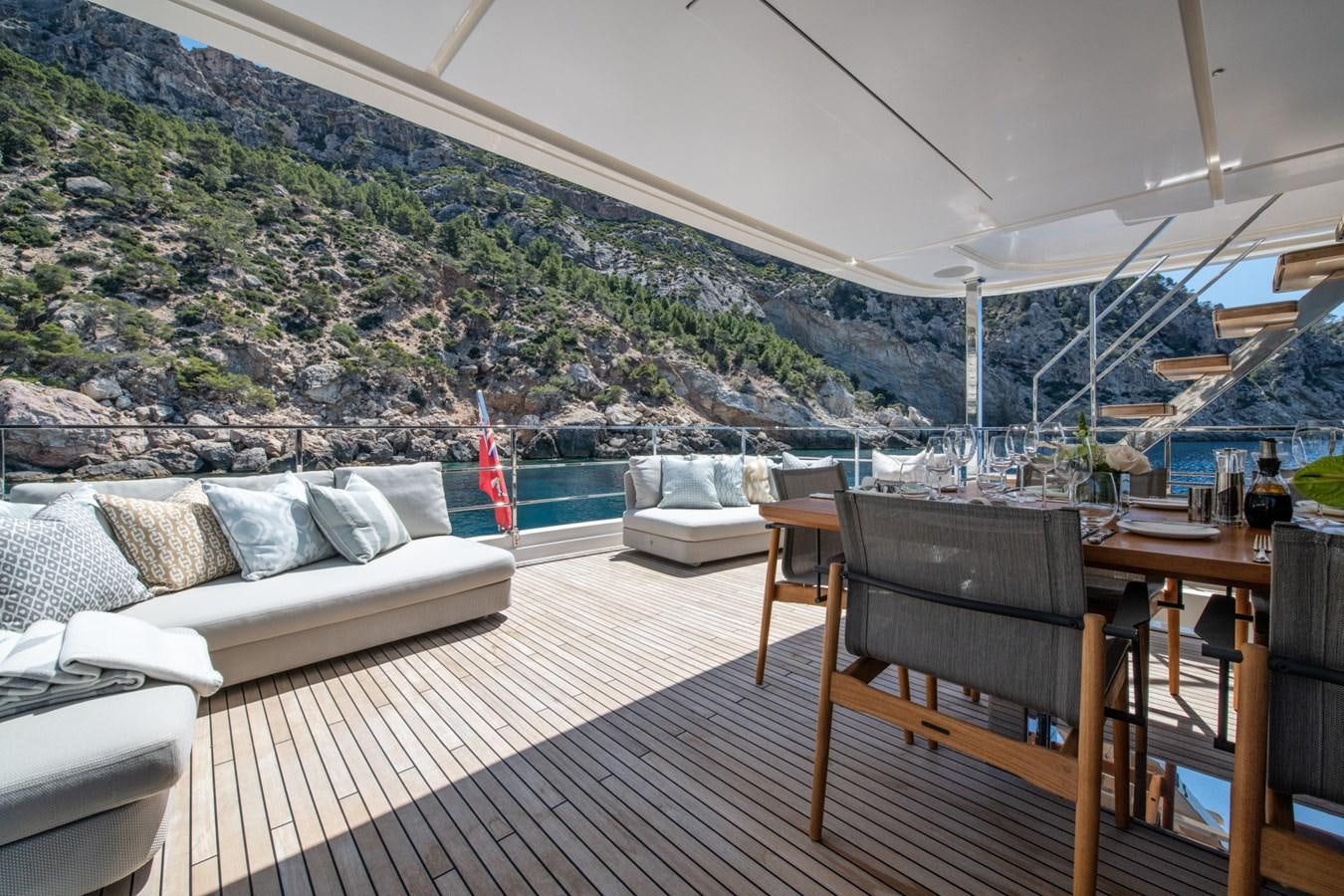 a deck with a view of a mountain and a pool aboard MAC ONE Yacht for Sale