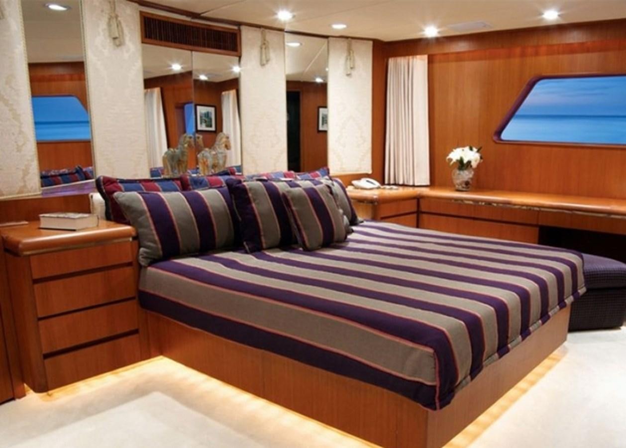 a bed with blue and purple sheets aboard HAPPY Yacht for Sale