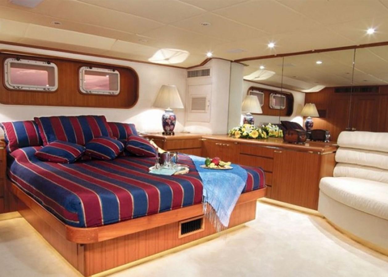 a bedroom with a blue bed aboard HAPPY Yacht for Sale