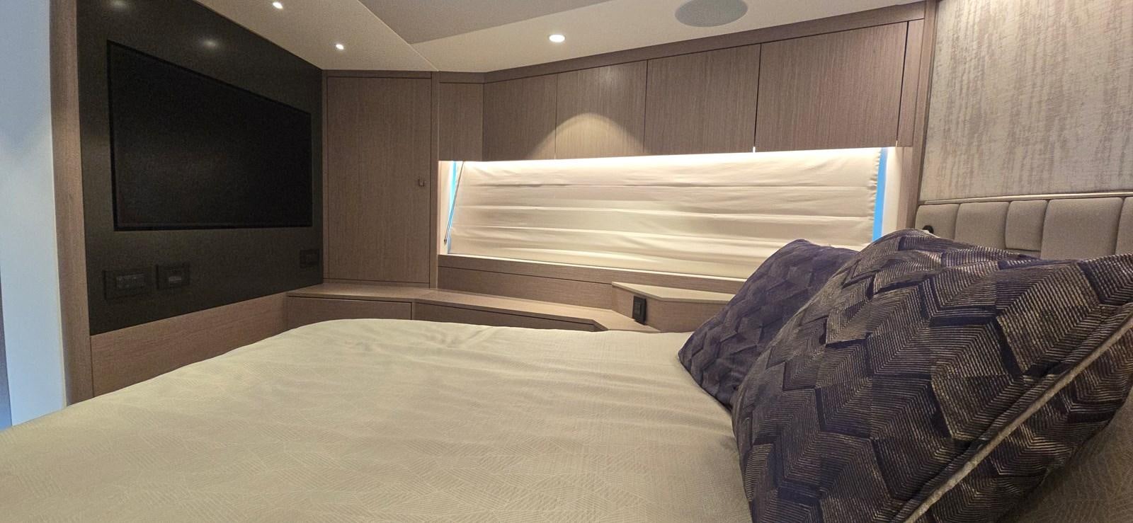 a bed with a television on the wall aboard GABY Yacht for Sale