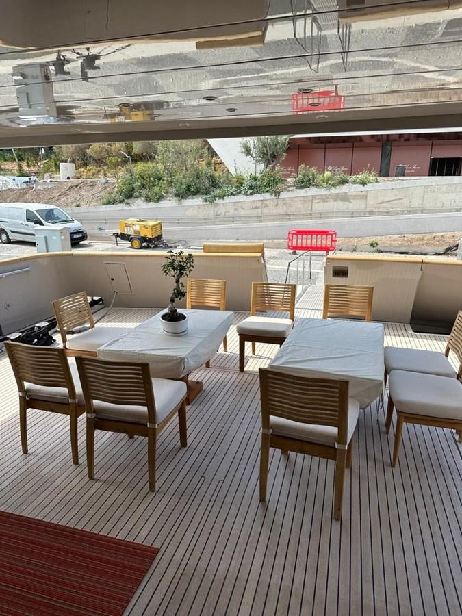 a table and chairs on a deck aboard CHRISTINA V Yacht for Sale