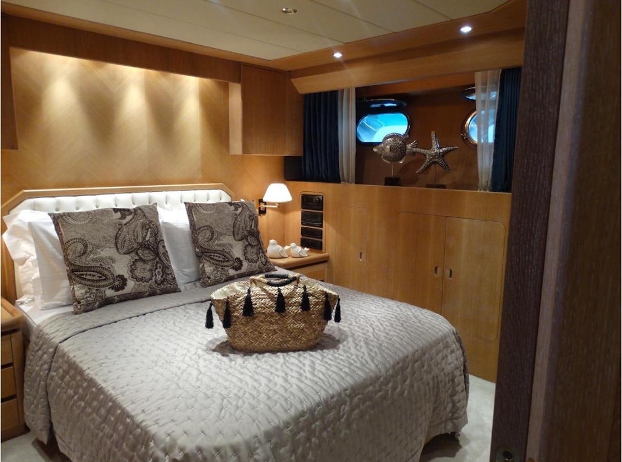 a bed with a round table and a mirror above it aboard CHRISTINA V Yacht for Sale