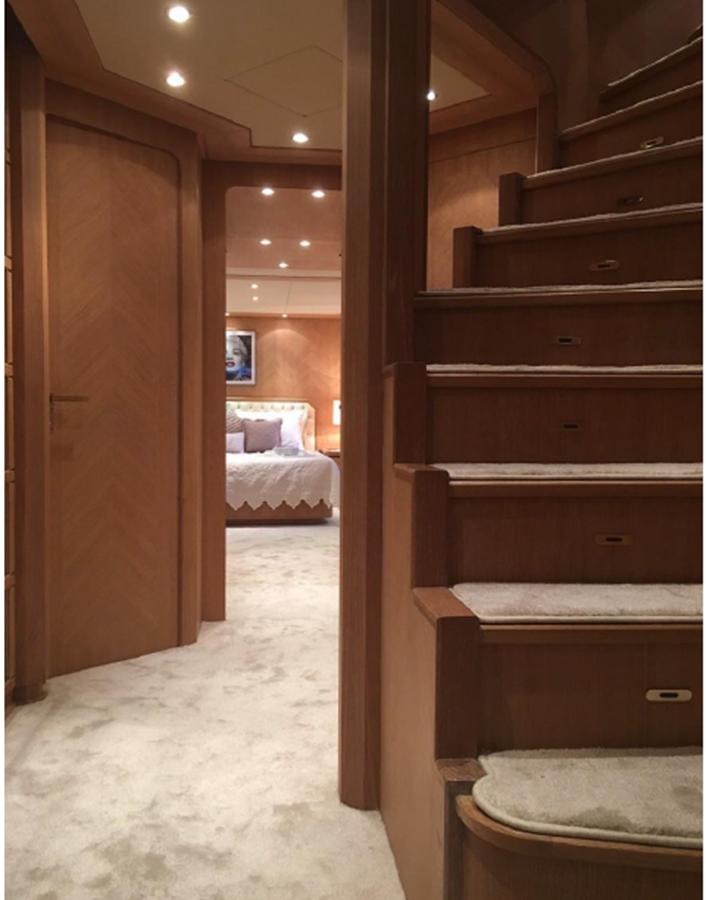a room with a bed and a dresser aboard CHRISTINA V Yacht for Sale