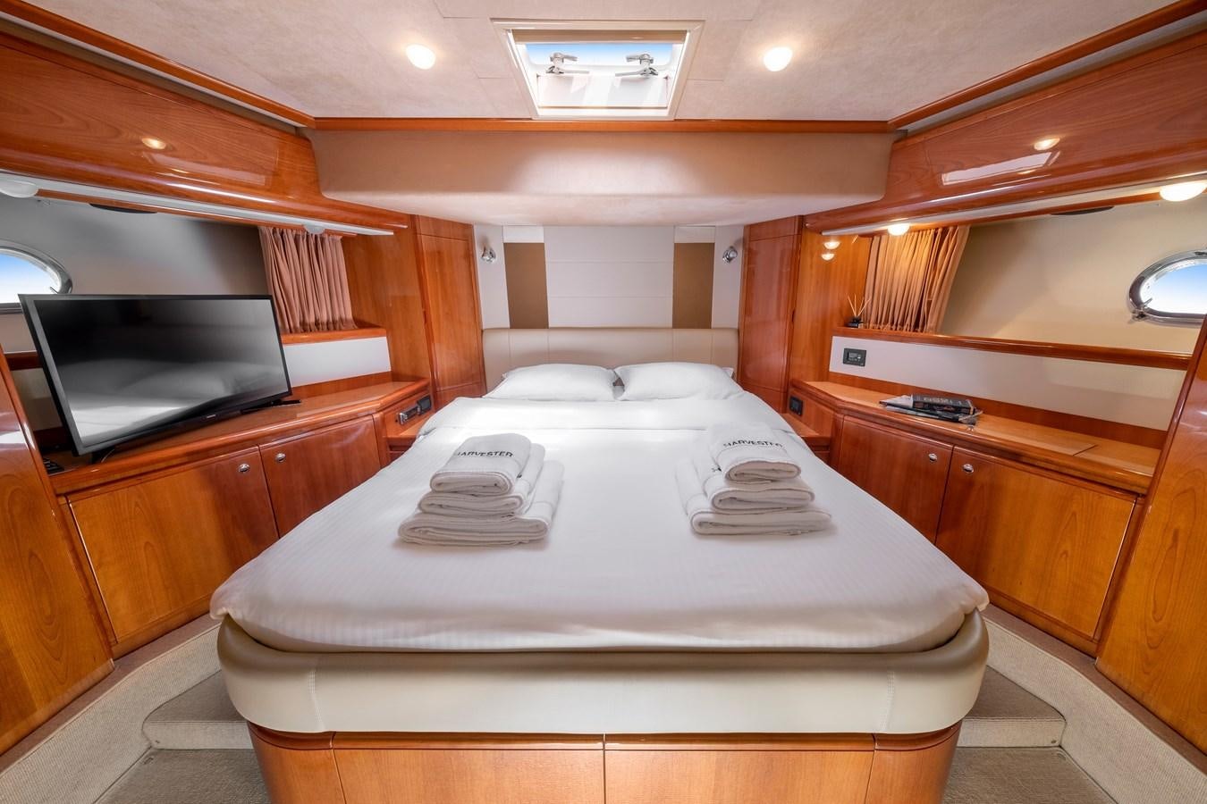a room with a bed and a mirror aboard HARVESTER Yacht for Sale