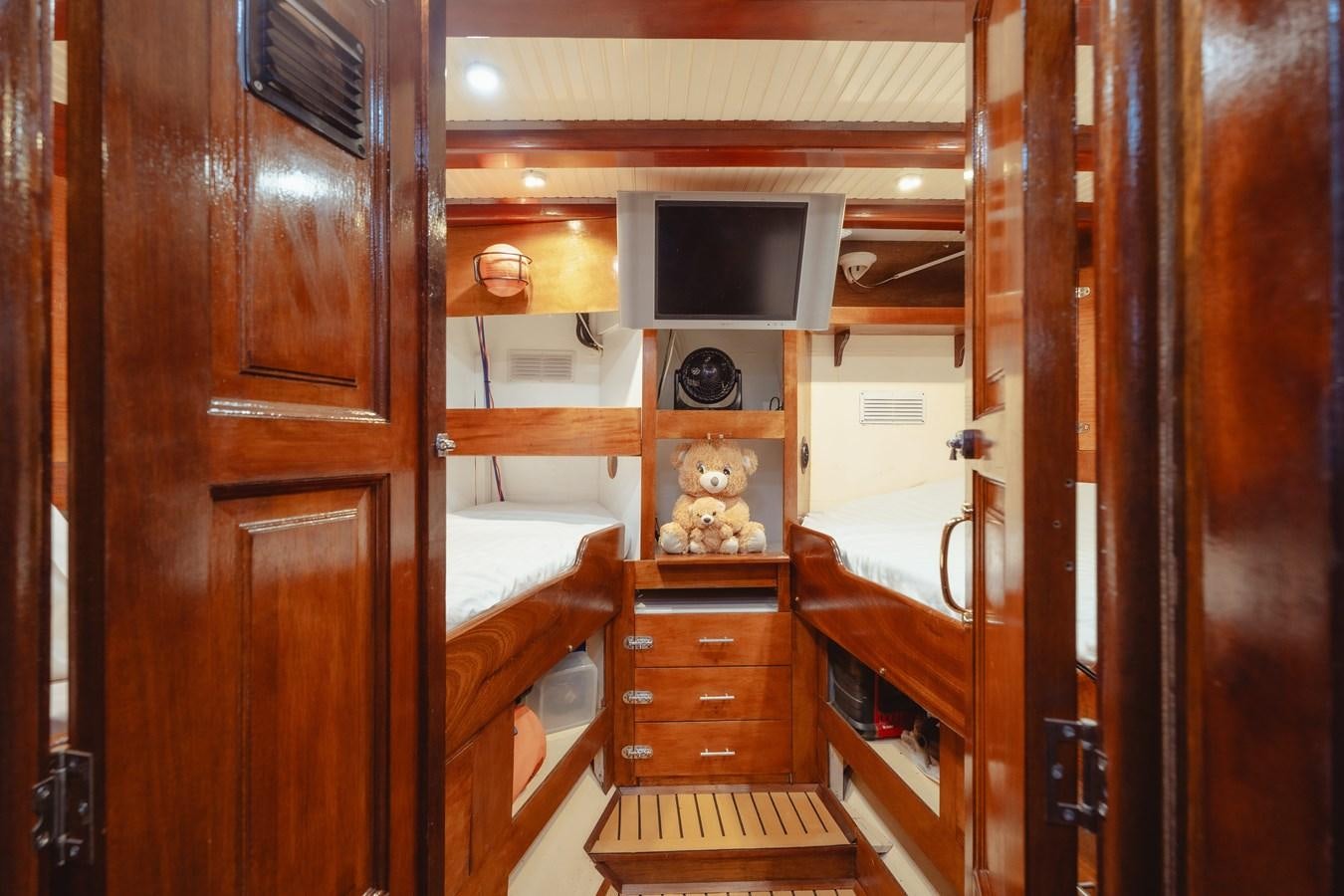 a wooden cabin with a bed and tv aboard SJOSTROM Yacht for Sale