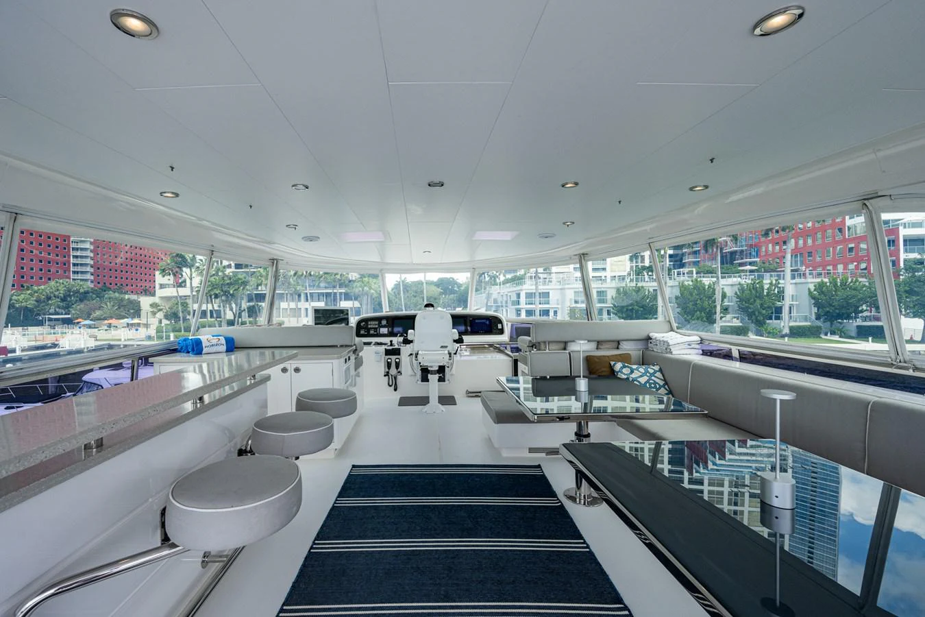a room with a large window and a black rug aboard MOIRA CINCO Yacht for Sale