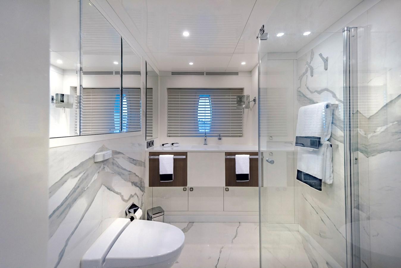 a bathroom with a glass shower aboard LIQUID SKY Yacht for Sale