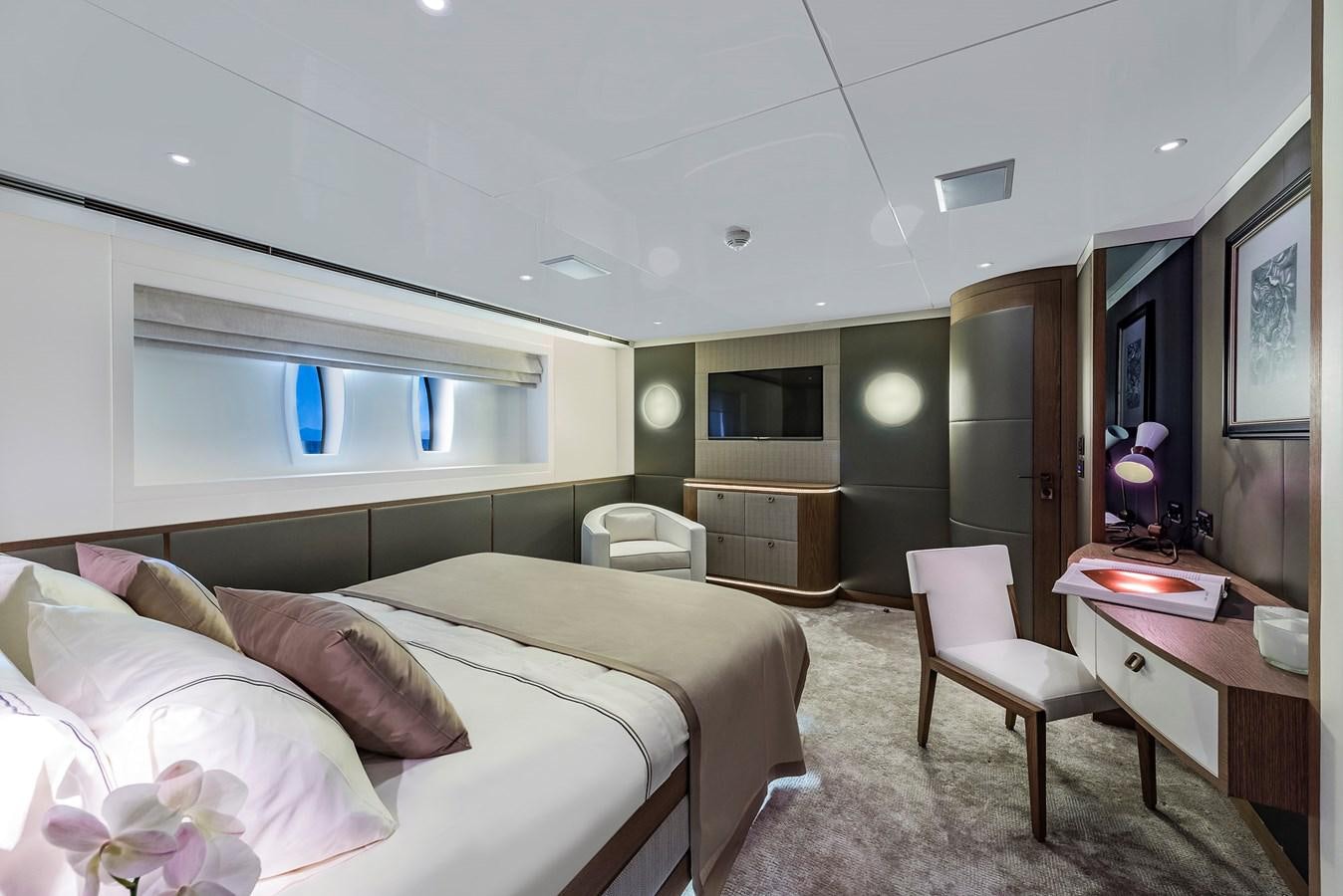 a bedroom with a bed and desk aboard LIQUID SKY Yacht for Sale