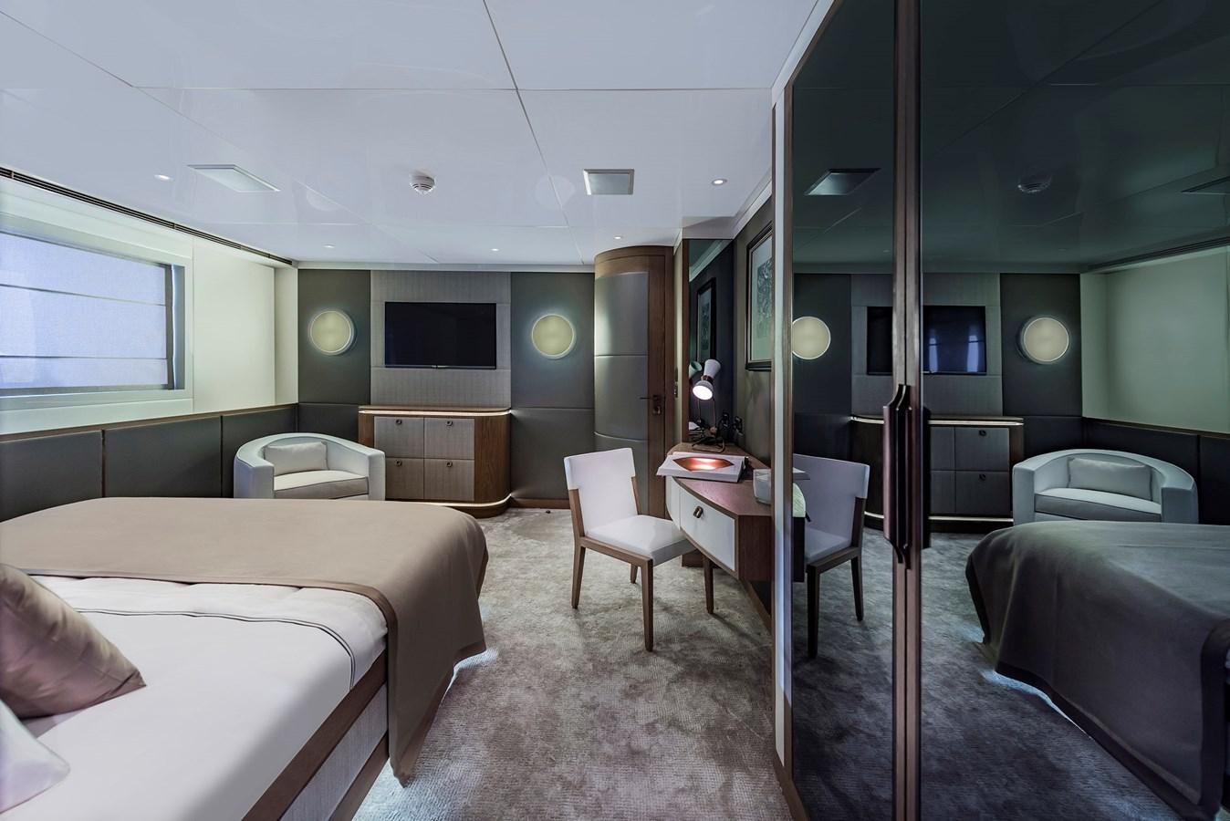 a bedroom with a bed and a desk aboard LIQUID SKY Yacht for Sale