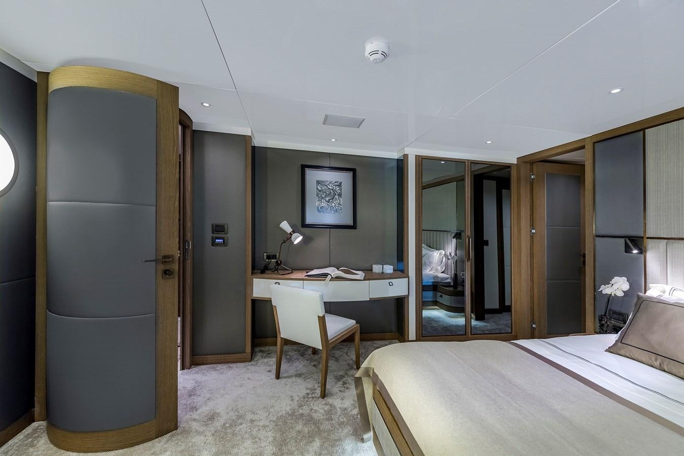a room with a bed and desk aboard LIQUID SKY Yacht for Sale