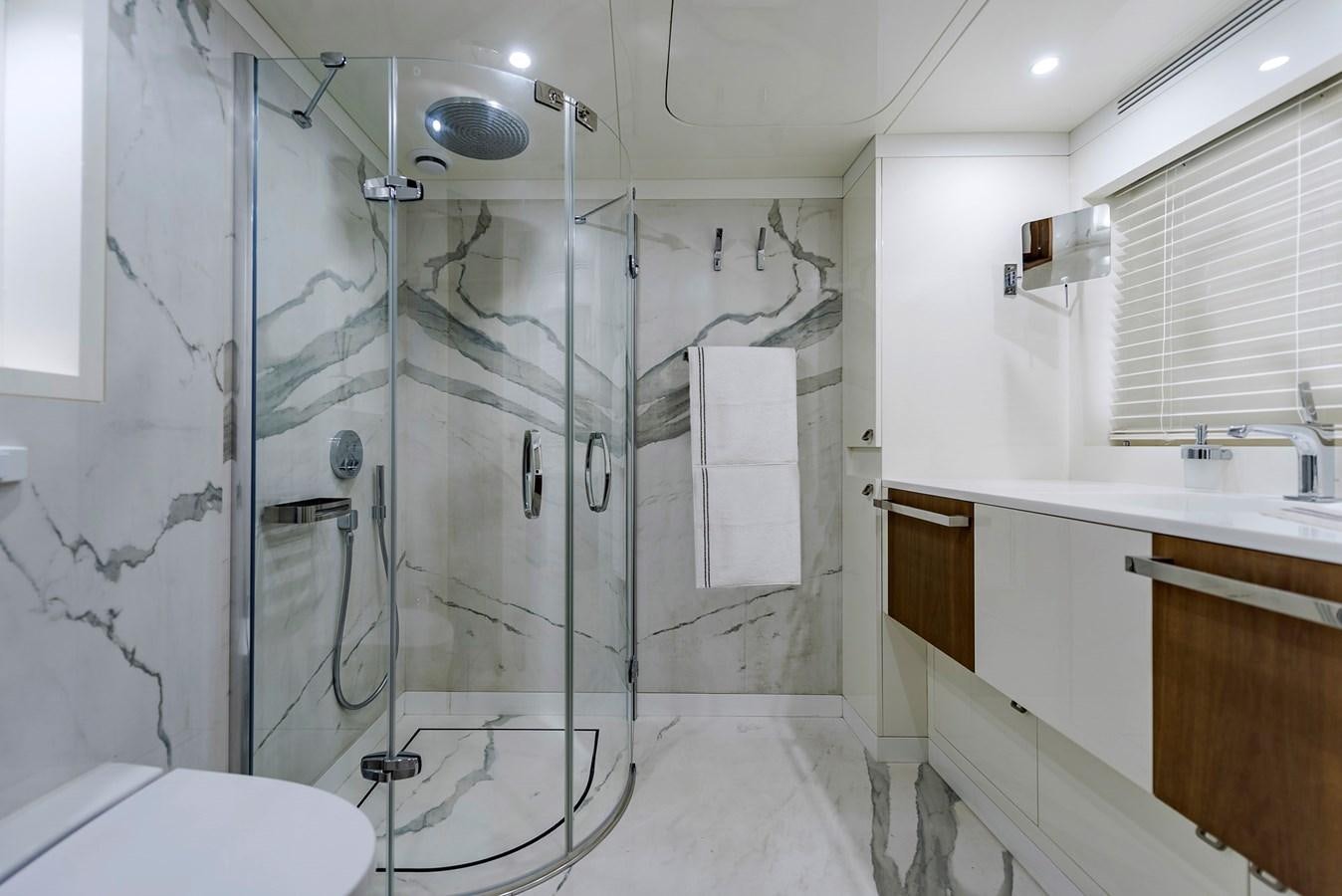 a bathroom with a glass shower aboard LIQUID SKY Yacht for Sale