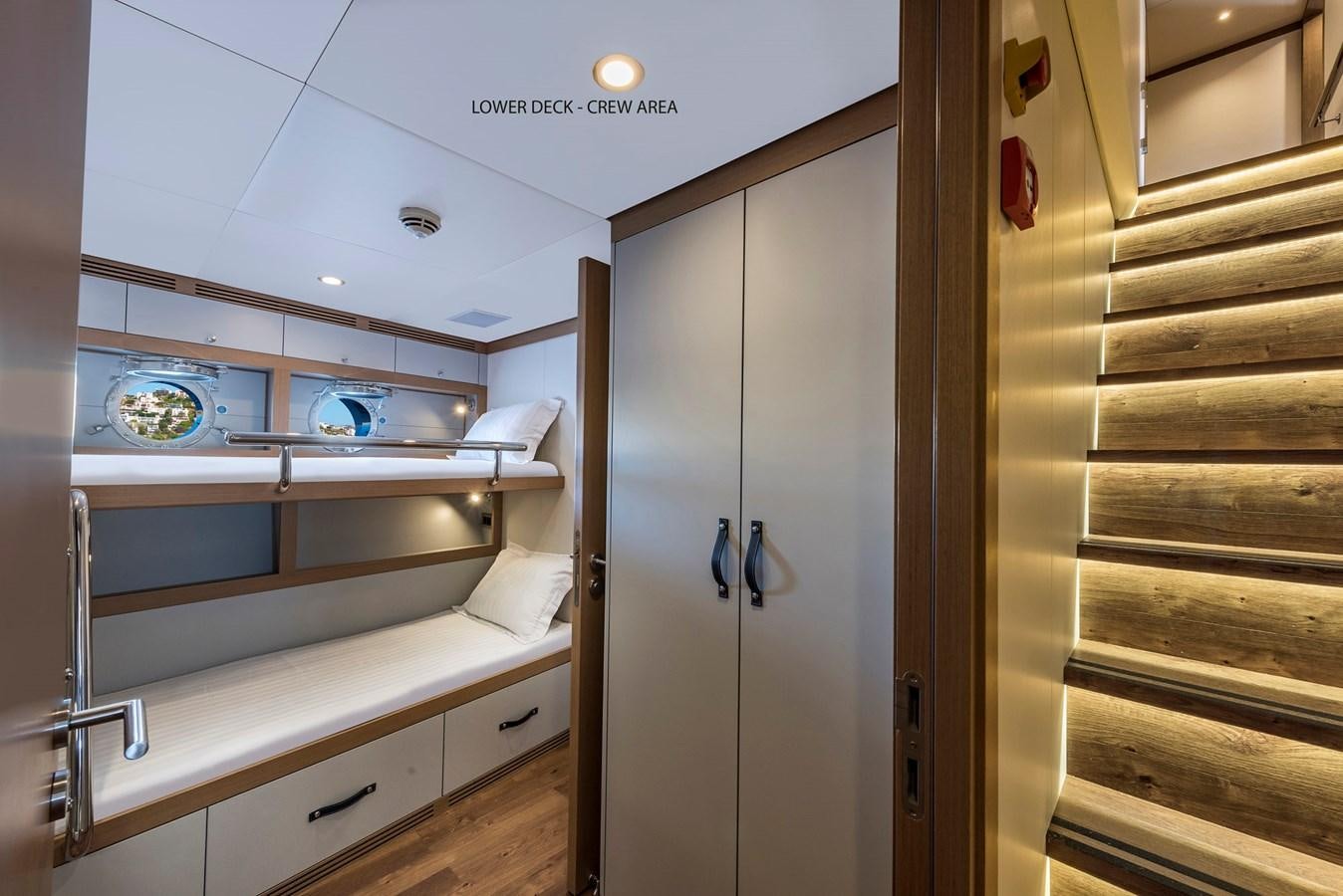 a room with a white door and a white bed and a white wall aboard LIQUID SKY Yacht for Sale