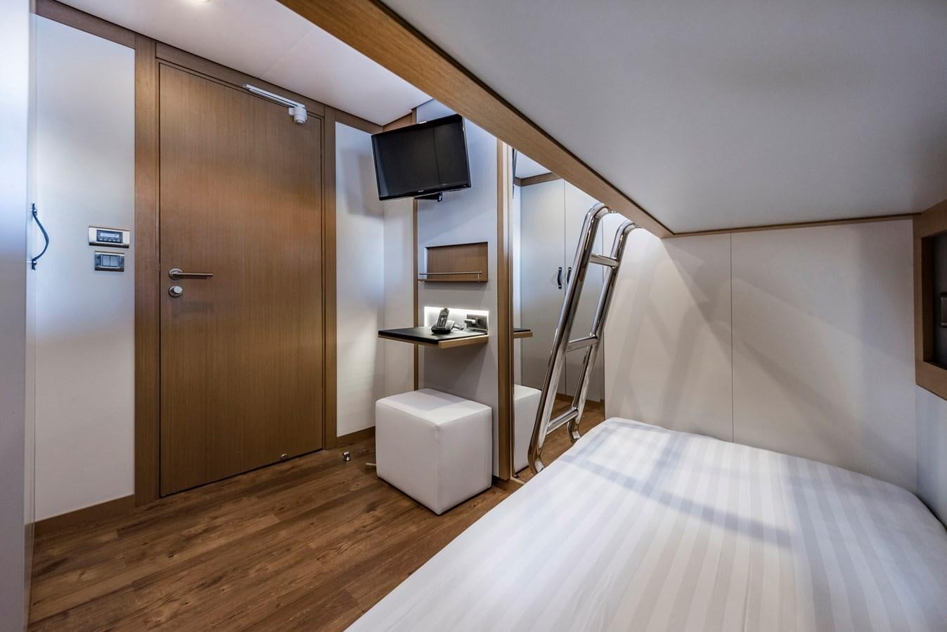 a bedroom with a bed and a television aboard LIQUID SKY Yacht for Sale