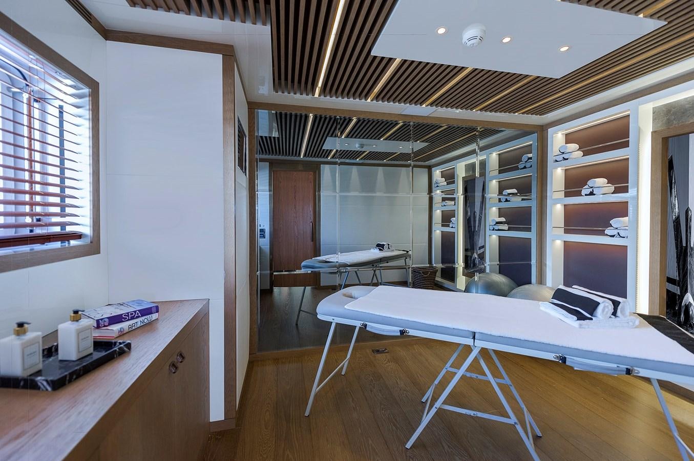 a room with a bed and desk aboard LIQUID SKY Yacht for Sale