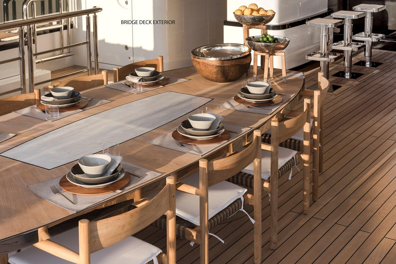 a wooden table with many plates on it aboard LIQUID SKY Yacht for Sale