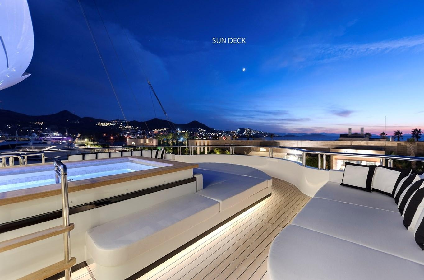 a large pool with a bridge and city in the background aboard LIQUID SKY Yacht for Sale