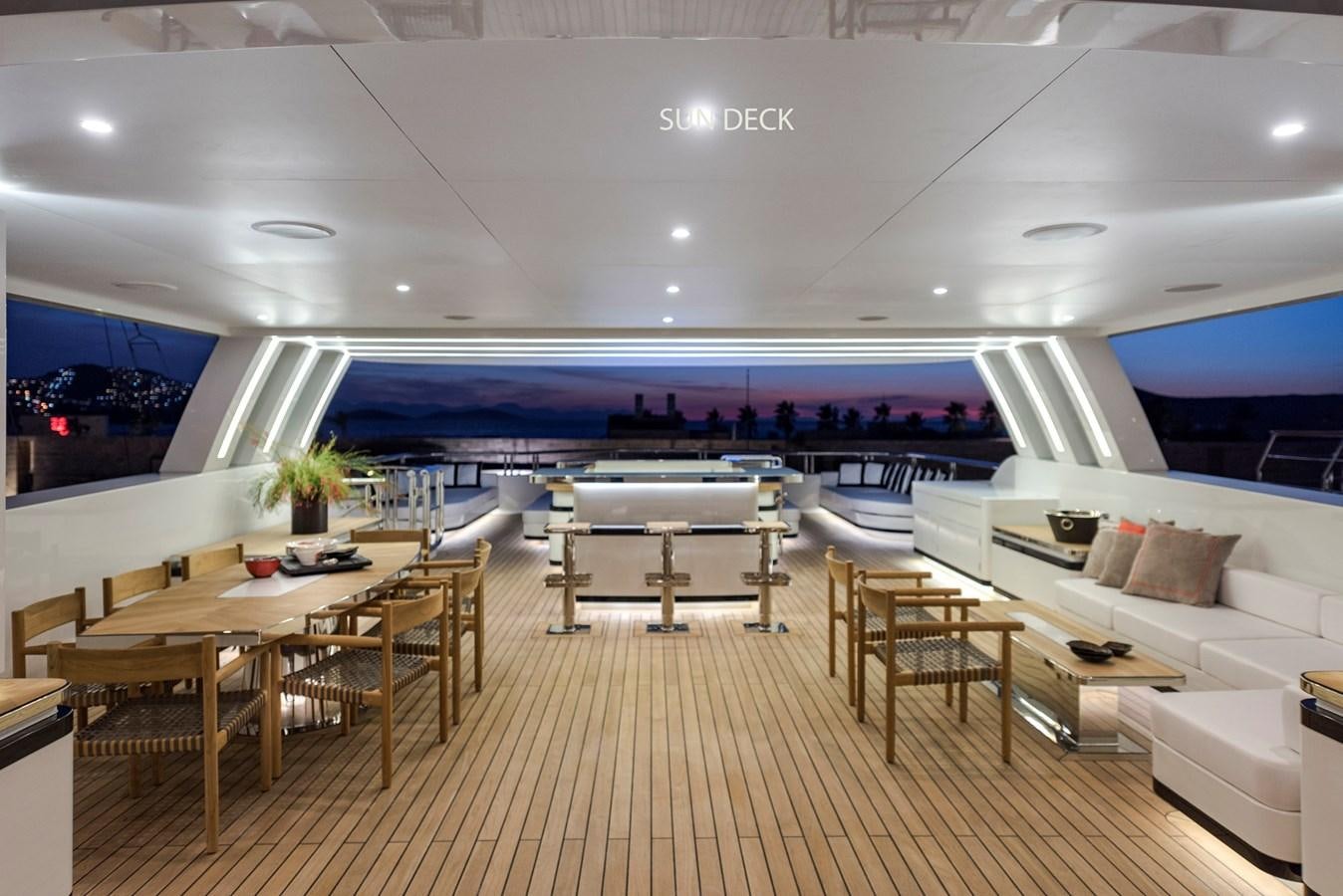 a room with tables and chairs aboard LIQUID SKY Yacht for Sale
