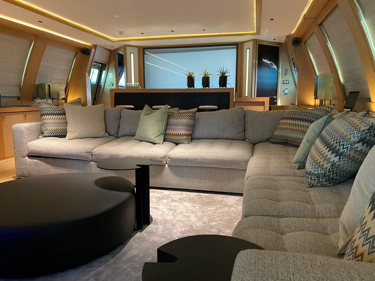 a living room with a couch and a large window aboard ESCAPE Yacht for Sale