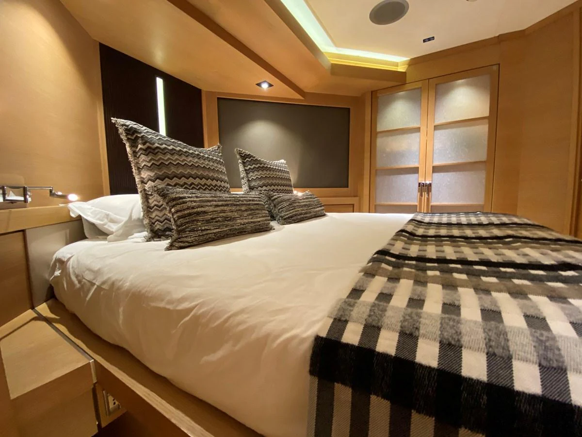 a bed with a white comforter aboard ESCAPE Yacht for Sale