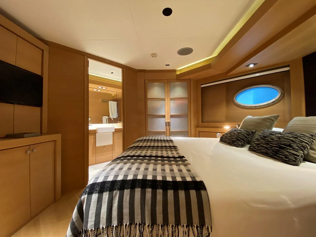a bed with a white and black checkered blanket aboard ESCAPE Yacht for Sale