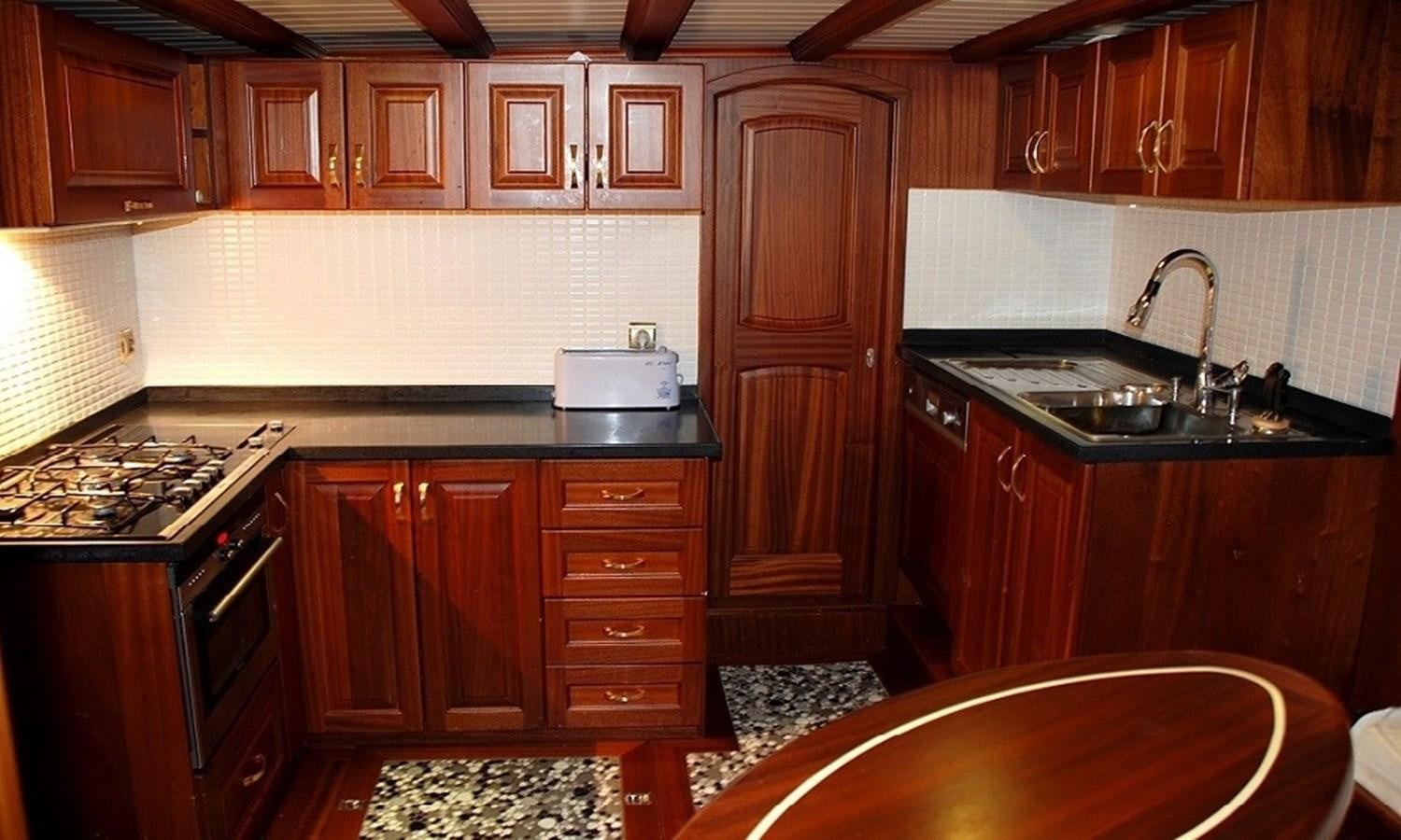 a kitchen with wooden cabinets aboard ATALANTE Yacht for Sale