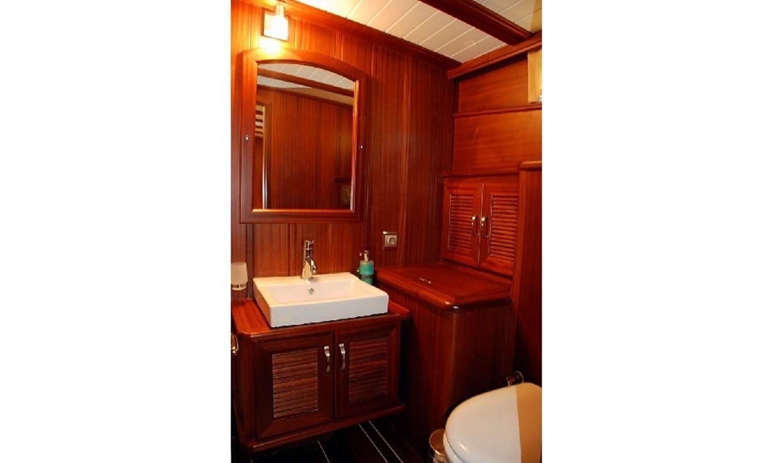 a bathroom with wooden cabinets aboard ATALANTE Yacht for Sale