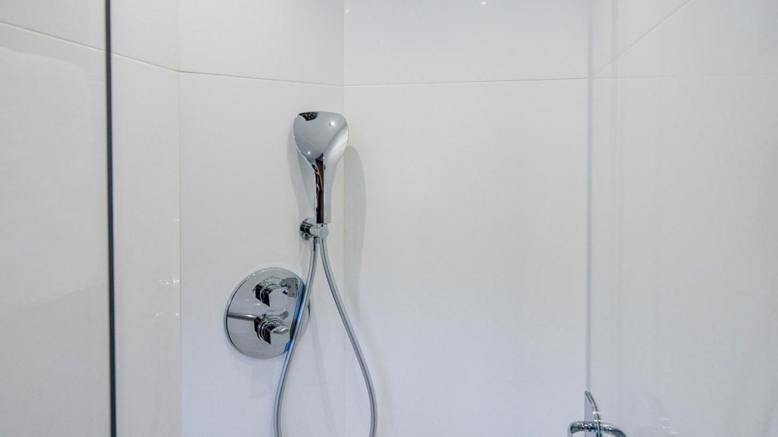 a shower head in a white tiled room aboard 76 YACHT Yacht for Sale