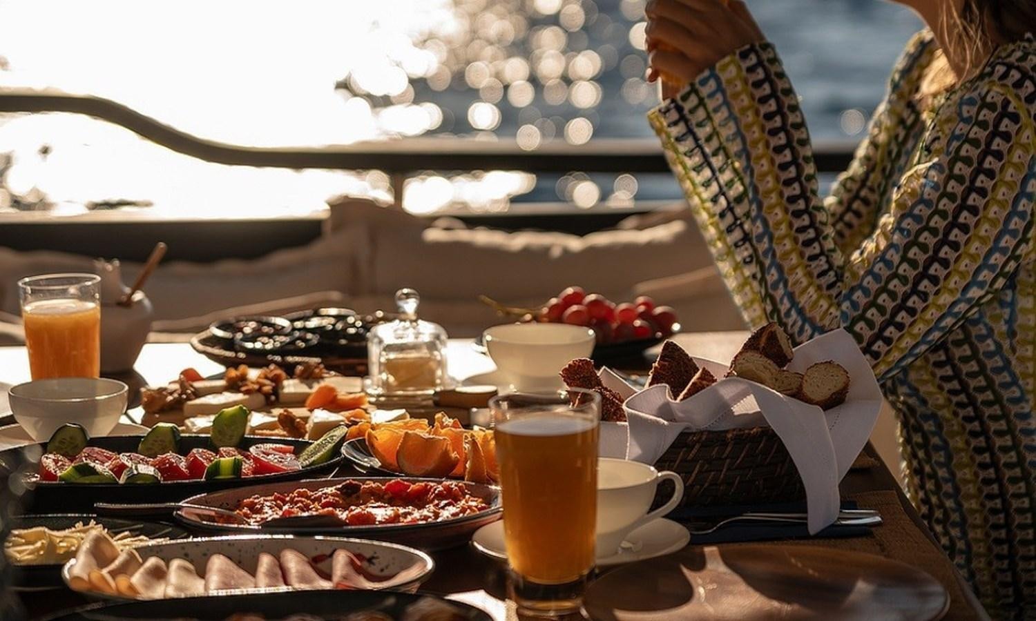 a table with food and drinks on it aboard CUSTOM MADE MOTORSAILOR Yacht for Sale