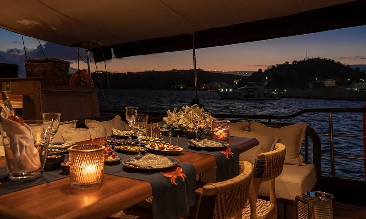 a table with food on it aboard CUSTOM MADE MOTORSAILOR Yacht for Sale