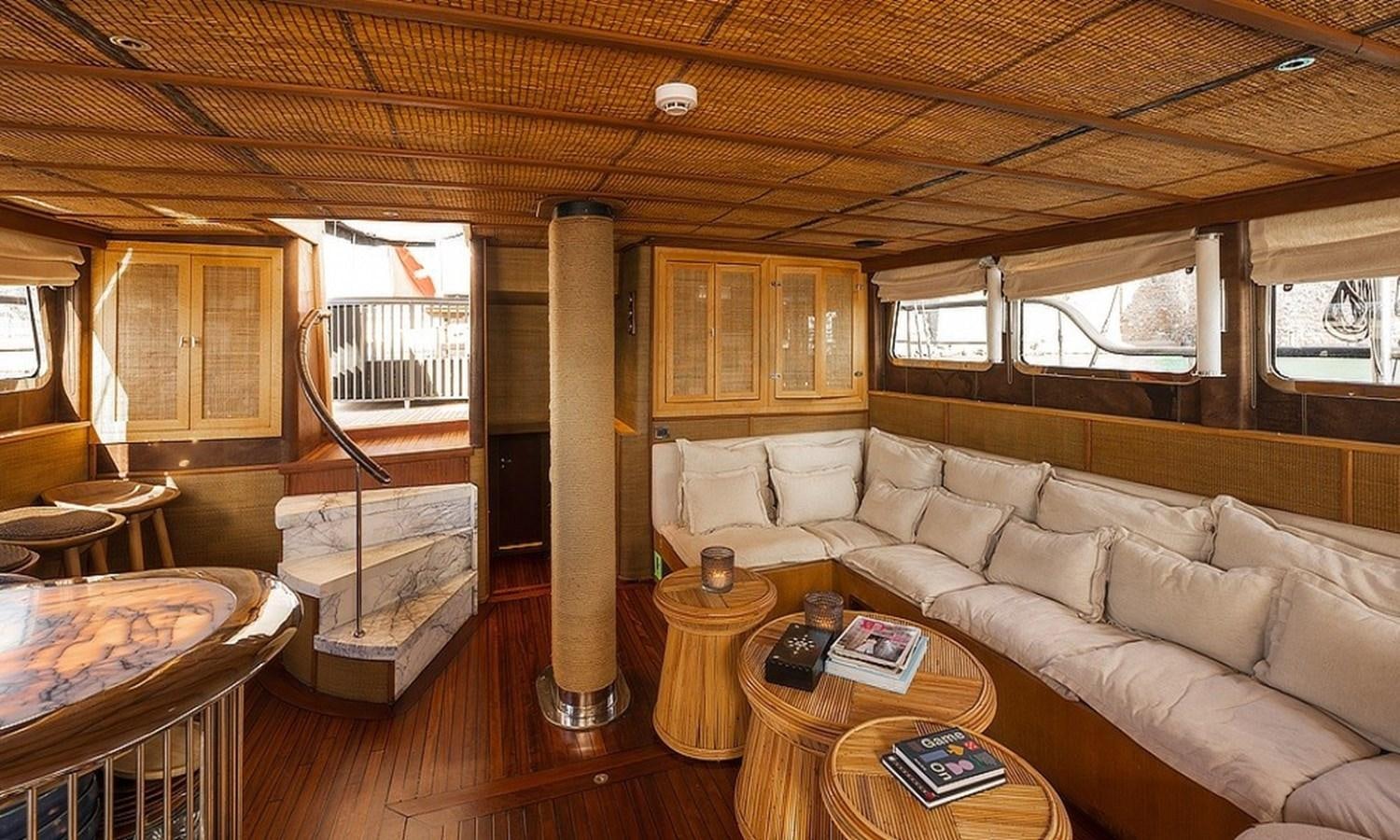 a living room with a couch and a table aboard CUSTOM MADE MOTORSAILOR Yacht for Sale